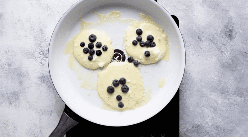 A delicious and easy blueberry pancake recipe cooked in a skillet.