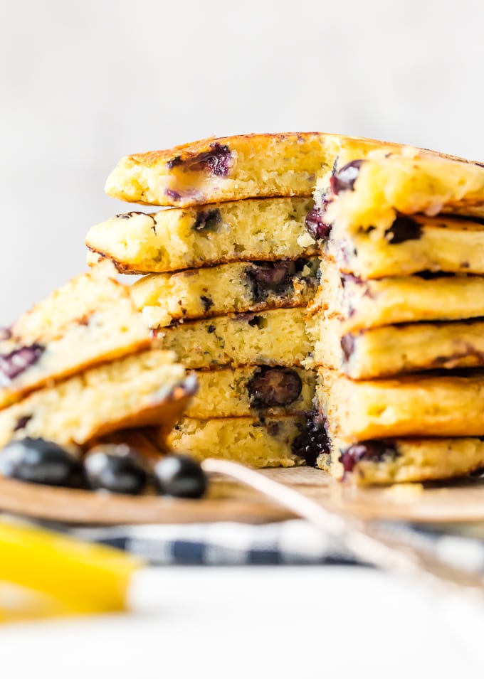 A stack of blueberry pancakes with a bite taken out