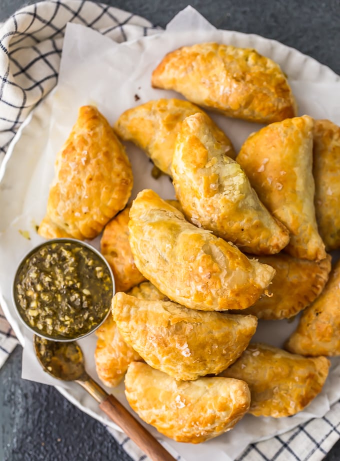 Chicken Curry turnovers on a plate with green sauce