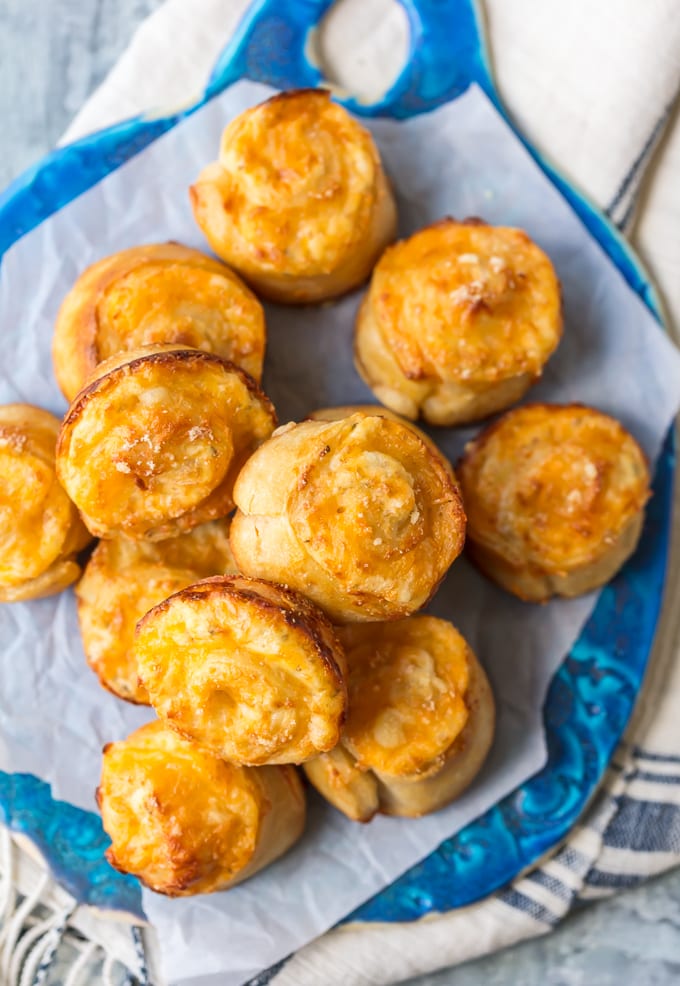 Garlic Cheese Roll Muffins stacked up on a blue serving plate