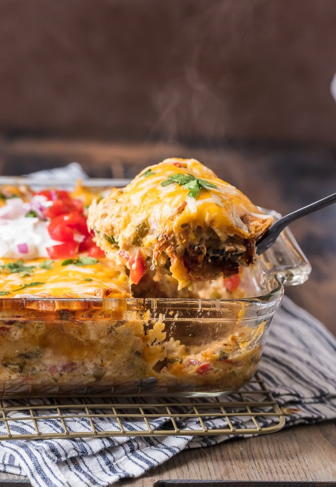 A spoonful of king ranch chicken being scooped out of a casserole dish