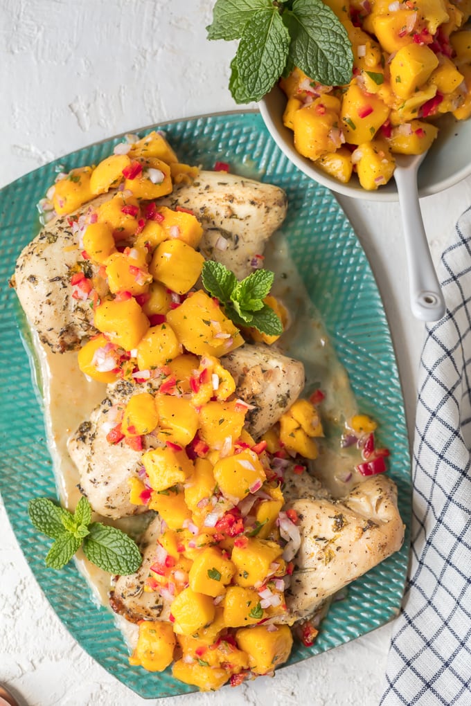 Plate of sangria chicken with manga salsa, next to a bowl of mango salsa