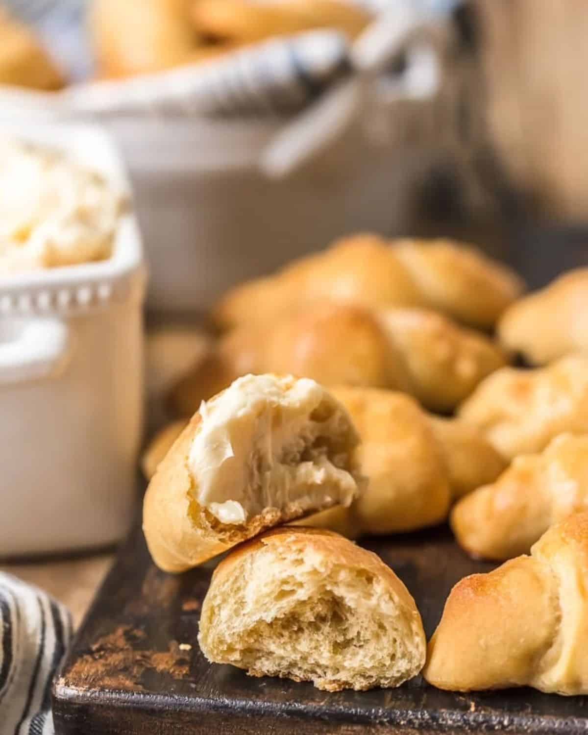 Dinner roll cut in half with honey butter on it.