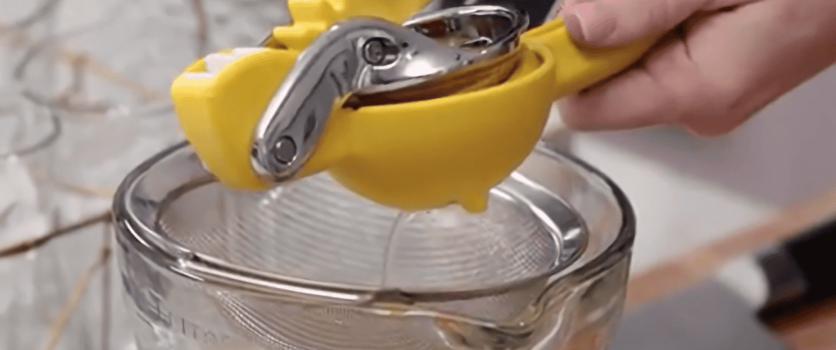 Squeezing lemon juice into a sieve.