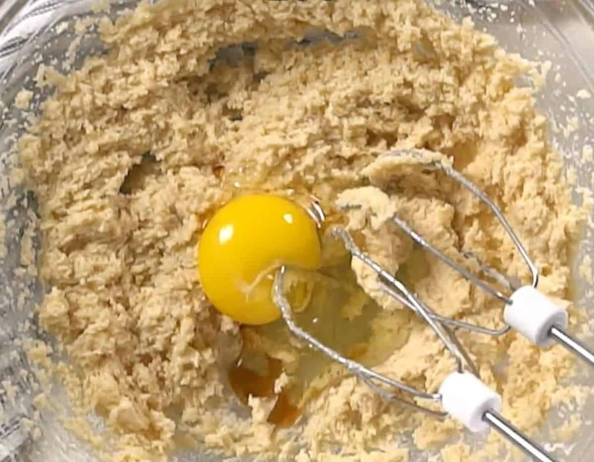 Adding an egg to the batter.