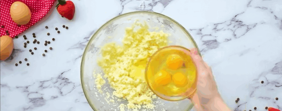 Adding eggs to the butter and sugar. 