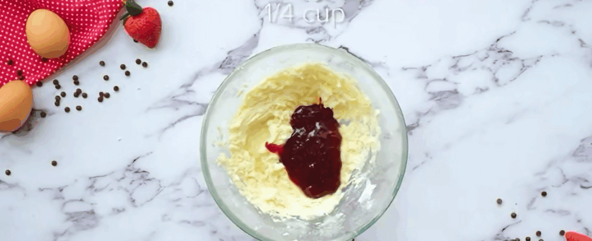 Adding jam to butter and powdered sugar mixture. 