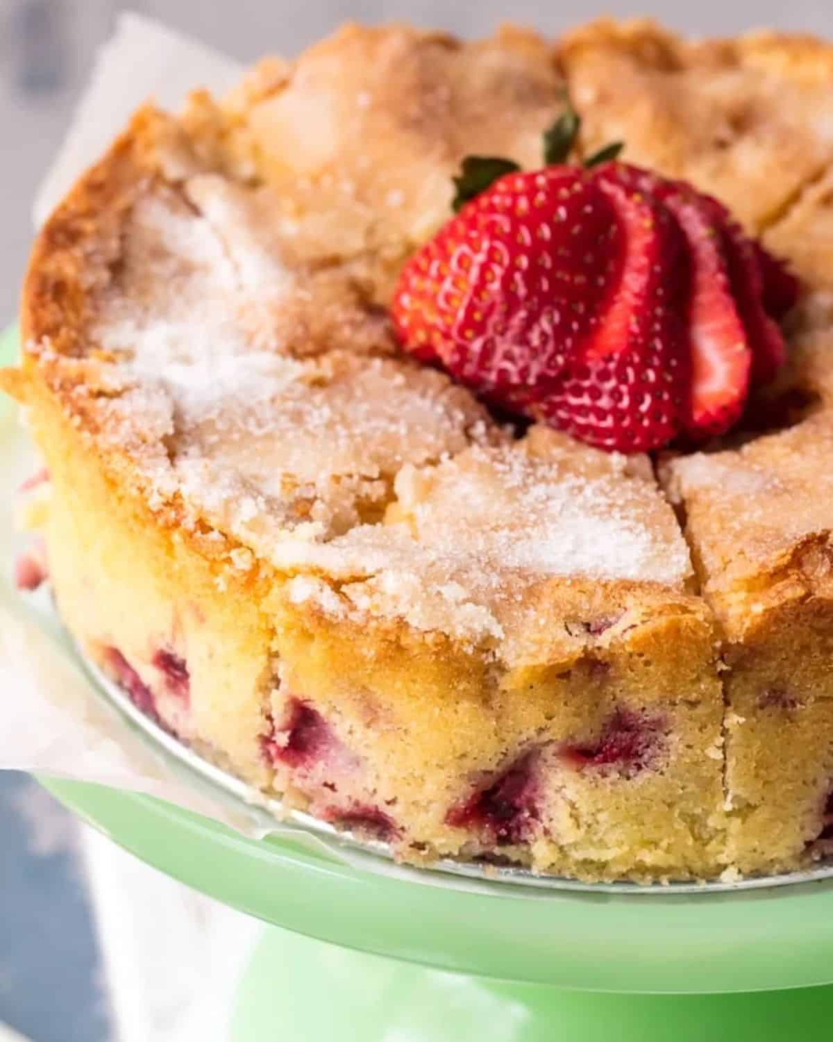 This Strawberry Buttermilk Cake is moist, soft, and so yummy! I love the light & simple flavor of this lemon strawberry cake. Strawberry buttermilk cake on a cake stand.