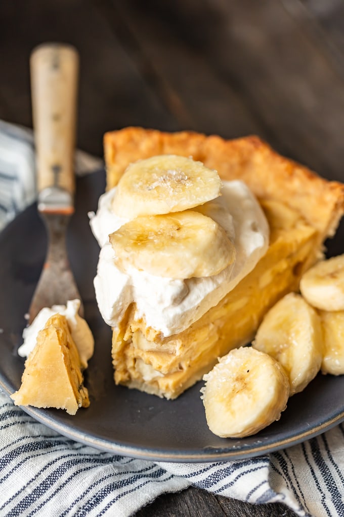 A piece of banana cream pie on a plate with sliced bananas