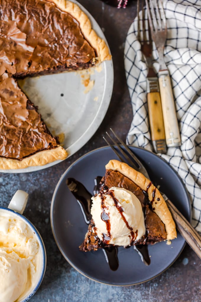 Brownie Pie is a rich, chocolaty dessert that's almost too good to be true! A homemade fudge brownie recipe baked straight into a pie crust gives you two desserts in one. A brownie pie next to a plate with a slice of pie