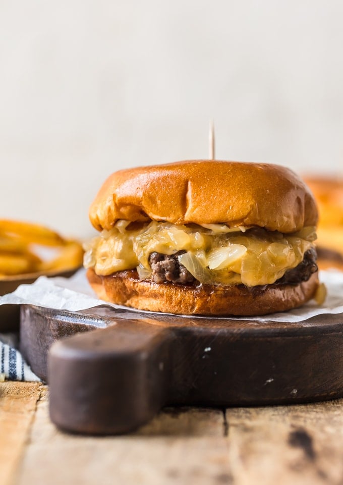 Burgers cooked in butter and topped with cheese and onions