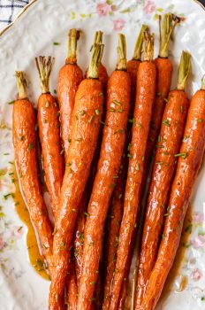 Honey Glazed Carrots with Ginger are sweet, aromatic, and absolutely tasty. This easy carrot side dish goes well with chicken, pork, or any holiday meal. I love these healthy honey roasted carrots because the flavor is so simple yet so amazing. This honey glazed carrots recipe should definitely be your next side dish!