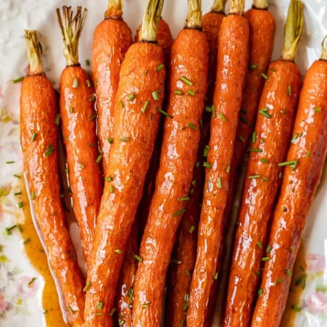 Honey Glazed Carrots with Ginger are sweet, aromatic, and absolutely tasty. This easy carrot side dish goes well with chicken, pork, or any holiday meal. I love these healthy honey roasted carrots because the flavor is so simple yet so amazing. This honey glazed carrots recipe should definitely be your next side dish!