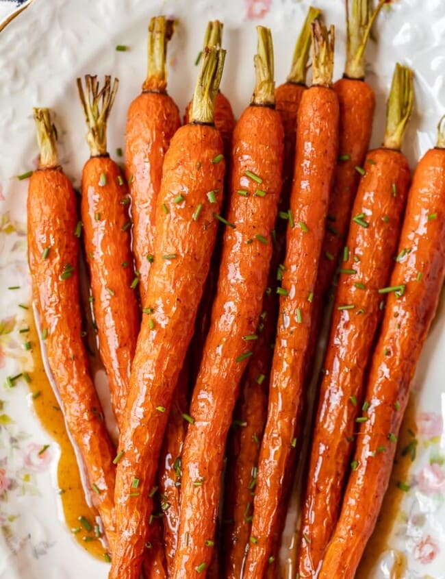 Honey Glazed Carrots with Ginger are sweet, aromatic, and absolutely tasty. This easy carrot side dish goes well with chicken, pork, or any holiday meal. I love these healthy honey roasted carrots because the flavor is so simple yet so amazing. This honey glazed carrots recipe should definitely be your next side dish!
