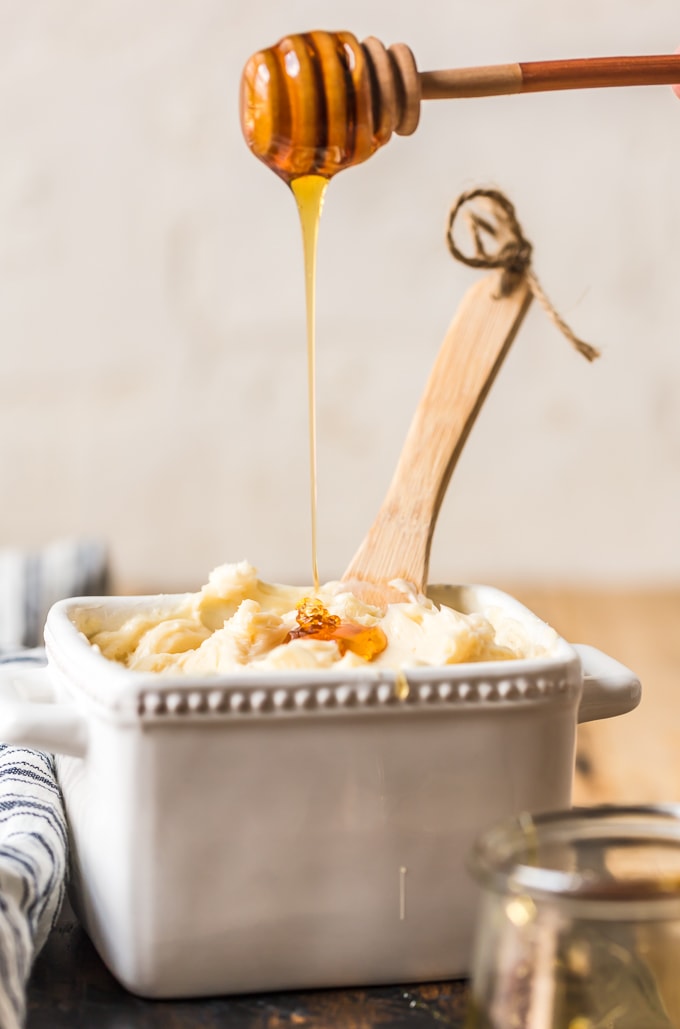 White container filled with butter, with honey drizzling into it