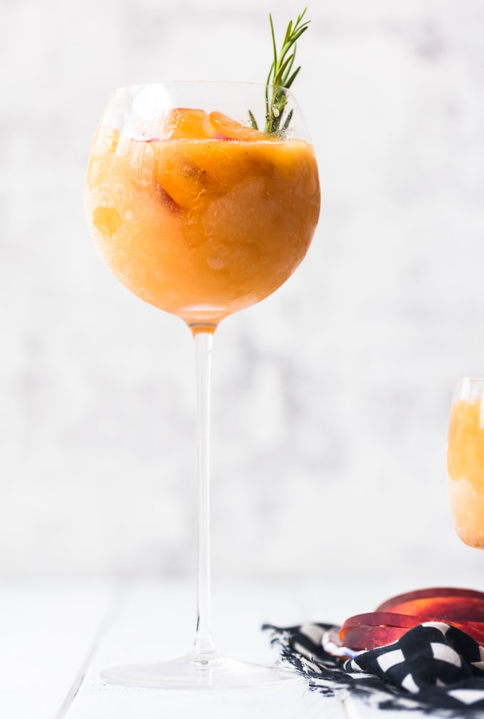 This Peach Frosé Recipe is a cocktail you definitely need for this hot Summer heat! All you need is frozen peaches, some Rosé wine, and a little honey. Frozen Rose is such a quick and easy fun cold drink to throw together for parties, friends and family, or just a quiet afternoon at home. We will show you how to make Frose and spice things up with this Peach Frose Recipe. So delicious, easy, fresh, and fun! Single glass of peach frose