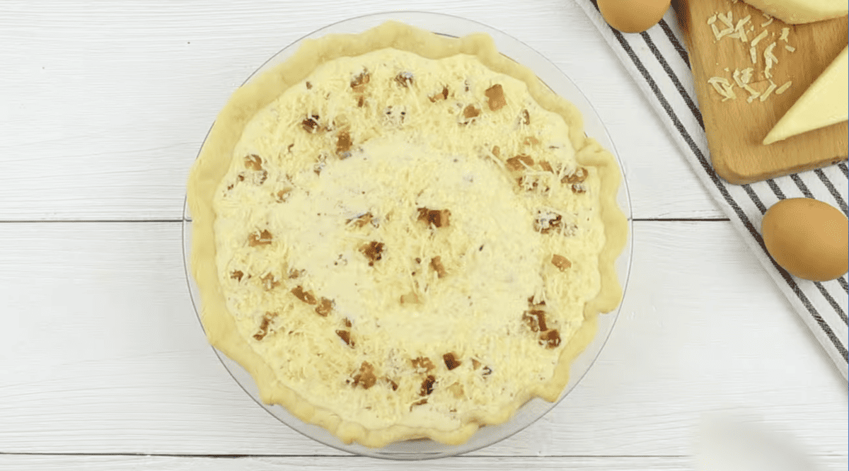 unbaked quiche lorraine in a pie crust.