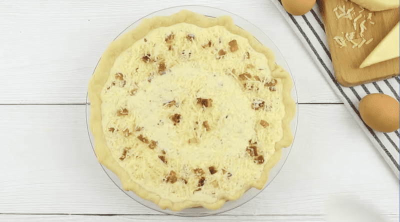 unbaked quiche lorraine in a pie crust.