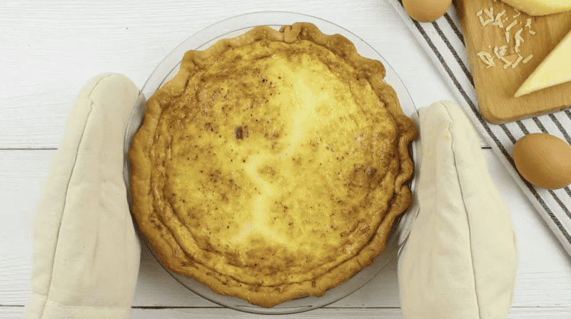 baked quiche lorraine on a white background.