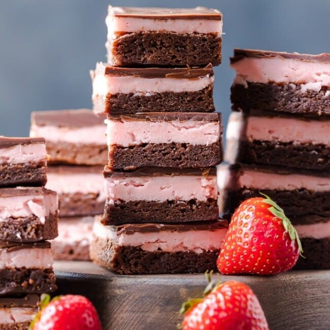 STRAWBERRY BROWNIES are perfect for Valentine's Day! This Chocolate Covered Strawberry Brownie Recipe is a mix of soft chocolate-y brownie, creamy strawberry filling, & a layer of melted chocolate.