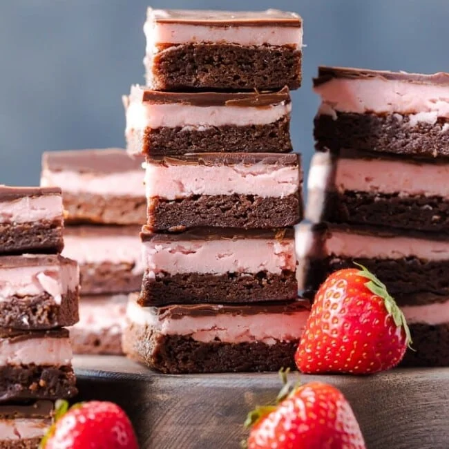 STRAWBERRY BROWNIES are perfect for Valentine's Day! This Chocolate Covered Strawberry Brownie Recipe is a mix of soft chocolate-y brownie, creamy strawberry filling, & a layer of melted chocolate.