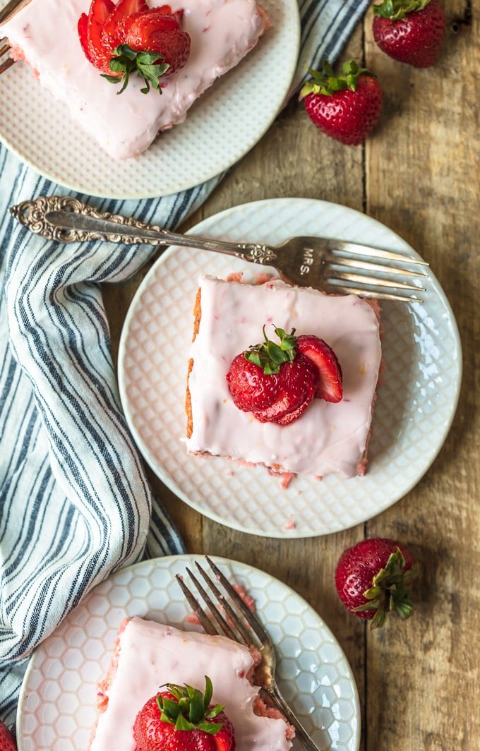 Slices of fresh strawberry cake on white plates