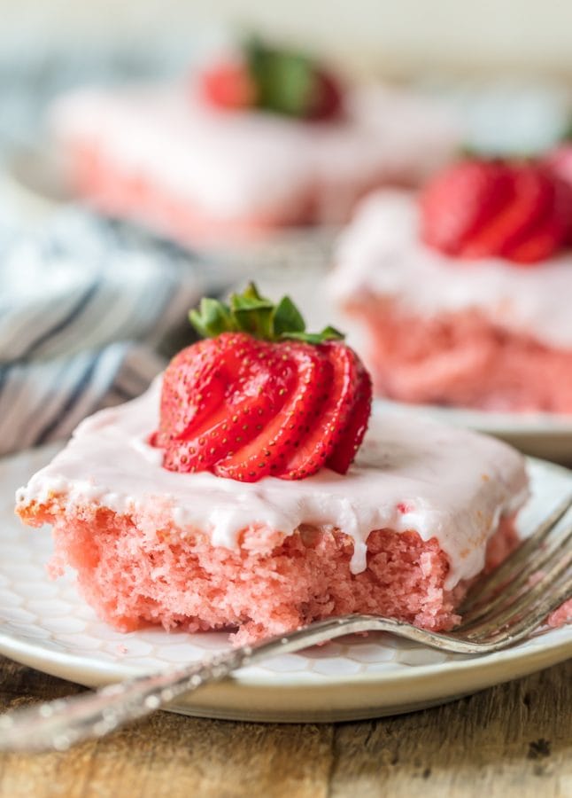 a slice of fresh strawberry cake on a plate with a fork.