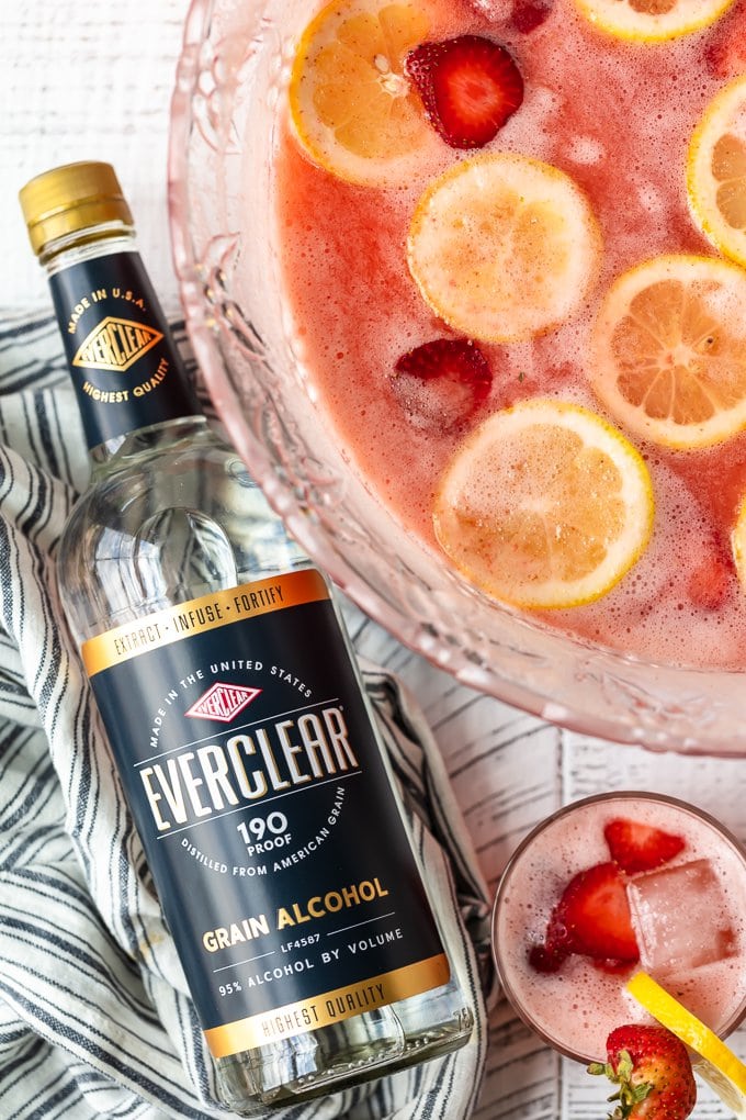 Strawberry Lemonade Party Punch is the best summer punch recipe! This refreshing drink is made with Everclear for the perfect party punch recipe. Strawberry Lemonade punch with a bottle of Everclear