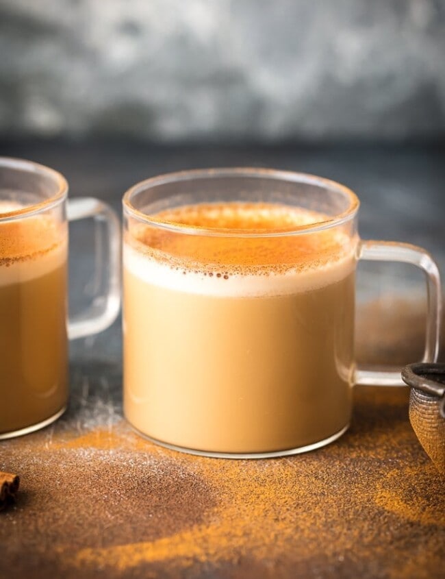 Two cups of bulletproof coffee with cinnamon on a table.