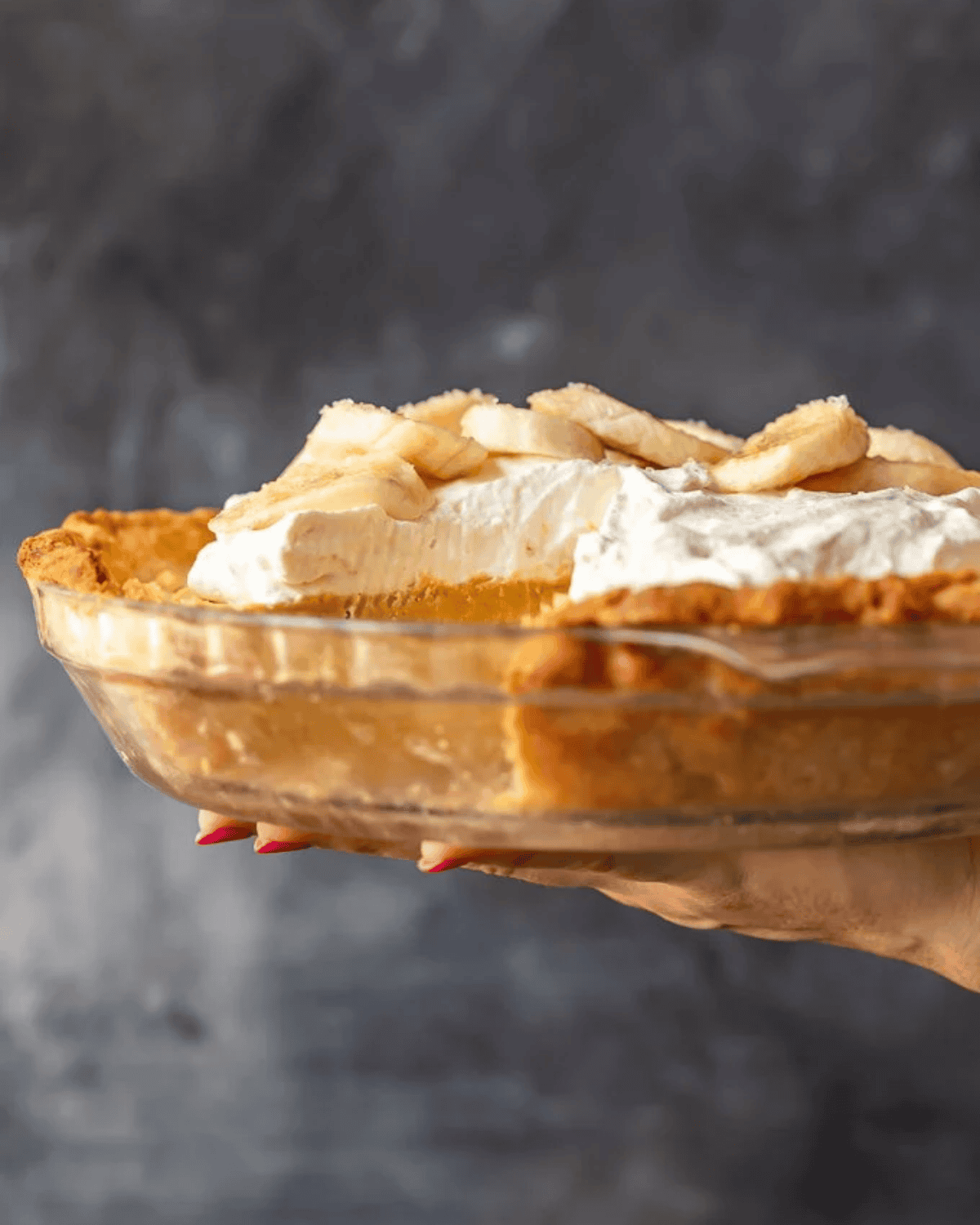 Side view of banana cream pie with a slice cut out.