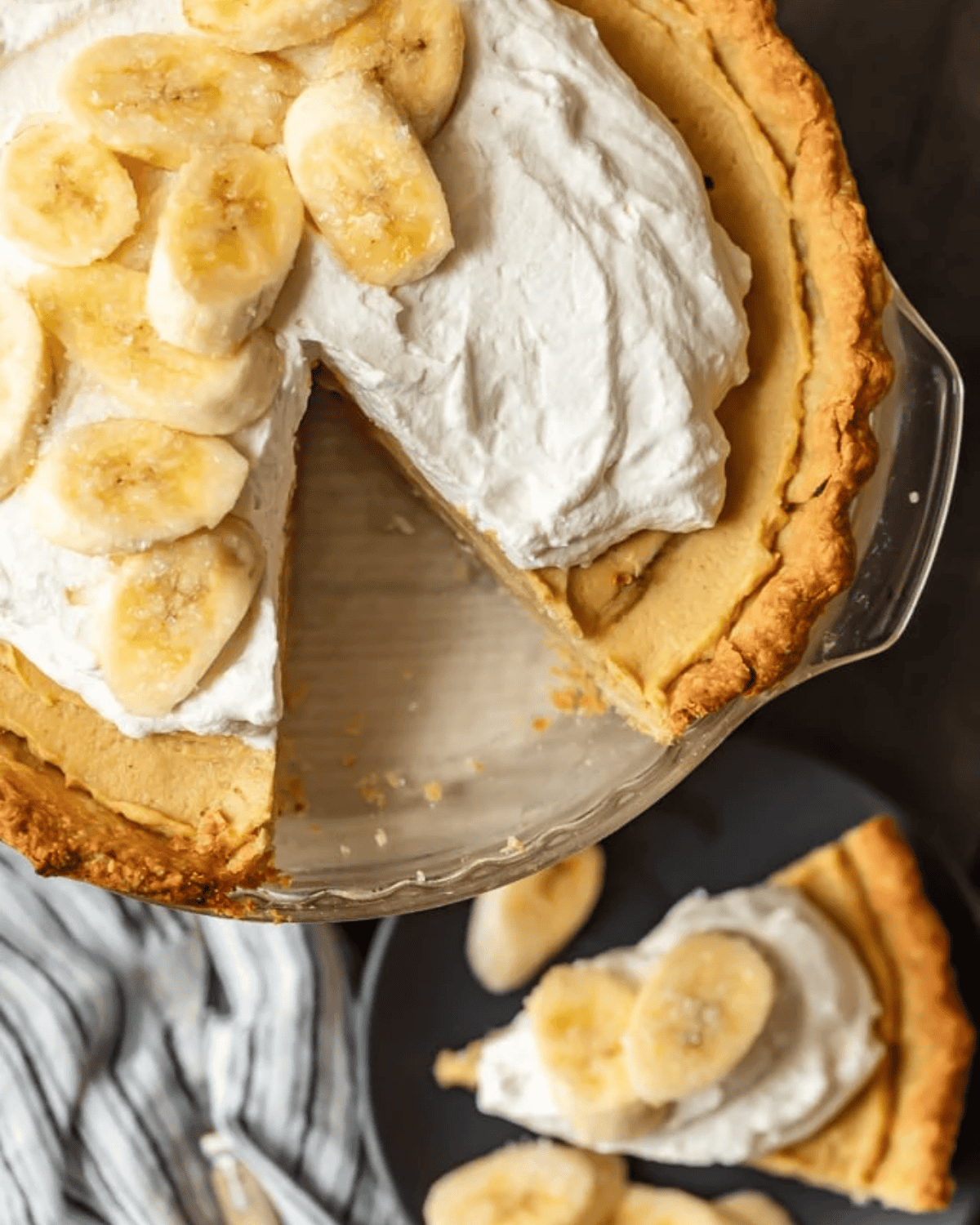 Banana Cream Pie is a creamy, delicious dessert filled with custard and fresh bananas. It's the perfect holiday recipe for Christmas, Easter, or Thanksgiving. This easy banana cream pie recipe is so rich and so tasty, everyone will love it! Banana cream pie with a slice cut out.