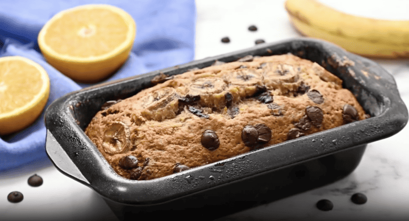 A loaf of chocolate chip banana bread in a loaf pan.