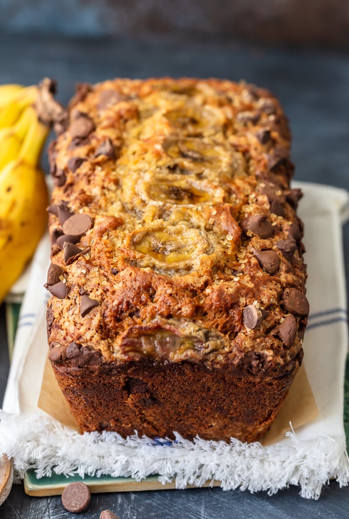 A loaf of chocolate chip banana bread on a white dish towel