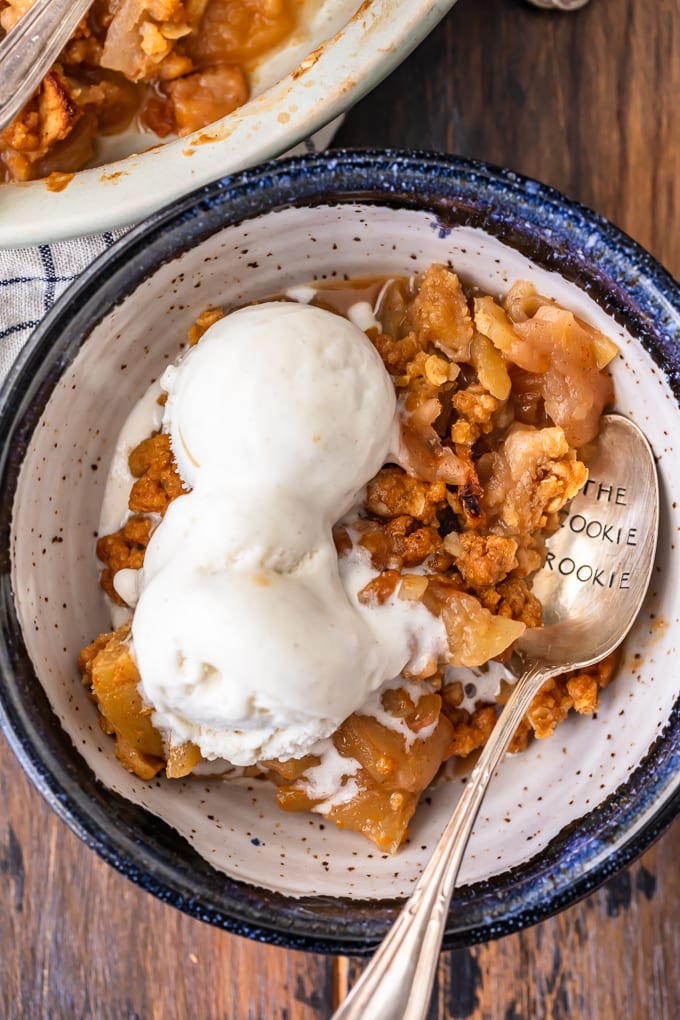 A bowl filled with fresh apple crisp topped with ice cream