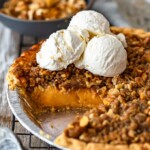 homemade sweet potato pie in a dish topped with scoops of vanilla ice cream