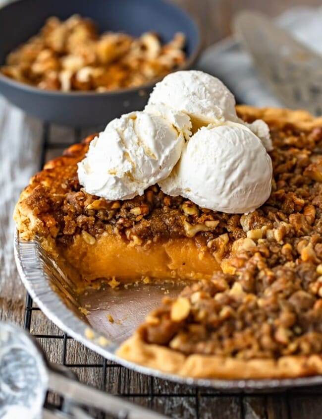 homemade sweet potato pie in a dish topped with scoops of vanilla ice cream