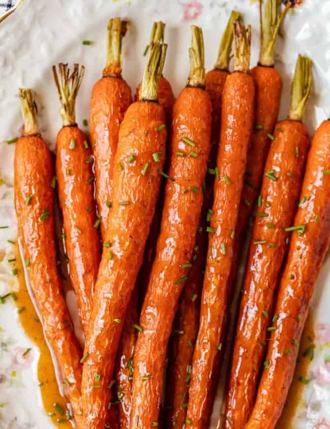 Honey glazed carrots on a white plate.