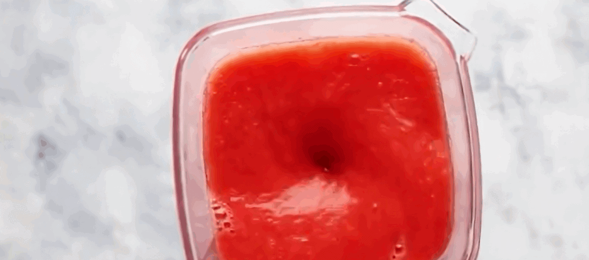 Blending strawberries and lemonade in the blender. 