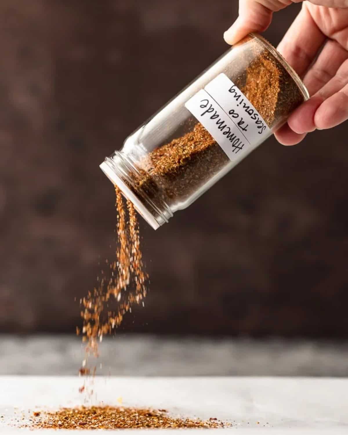 Homemade Taco Seasoning is an easy way to add some flavor to your recipes. This special blend of spices is just perfect for making tacos, casseroles, or any Mexican-inspired dish. Make your own taco seasoning in minutes, and keep it on hand for taco night or weeknight dinners! Taco seasoning being sprinkled.