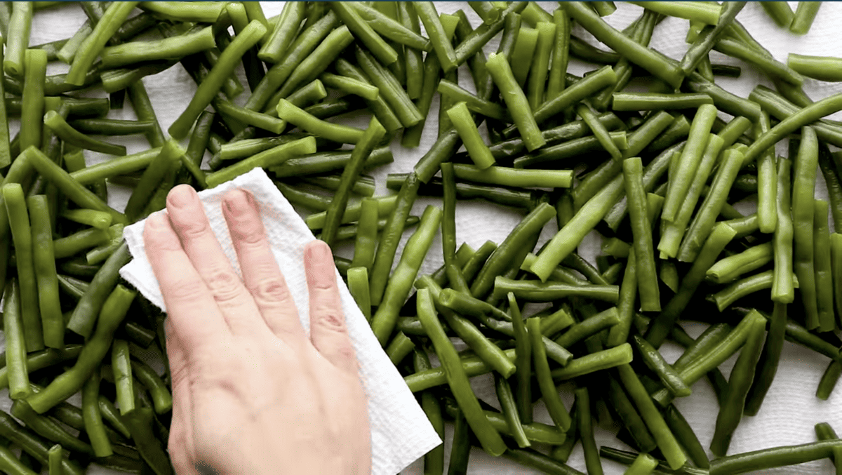 patting green beans dry with paper towels.