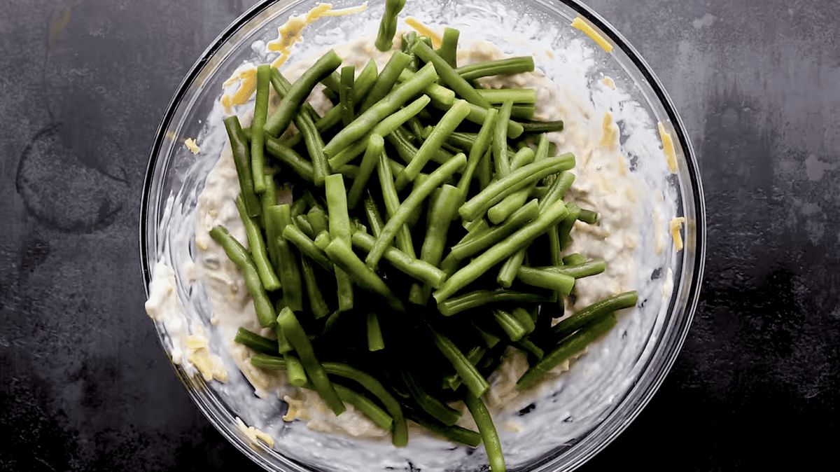 green beans on top of cheese filling in a glass bowl.