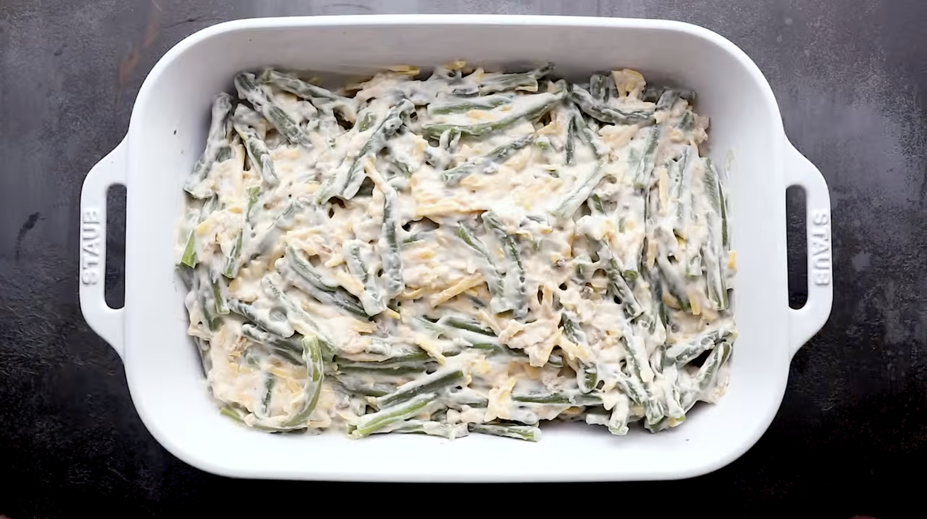 creamy green beans and cheese in a baking dish.