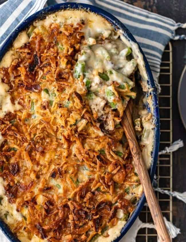 A green bean casserole dish with a spoon on top.