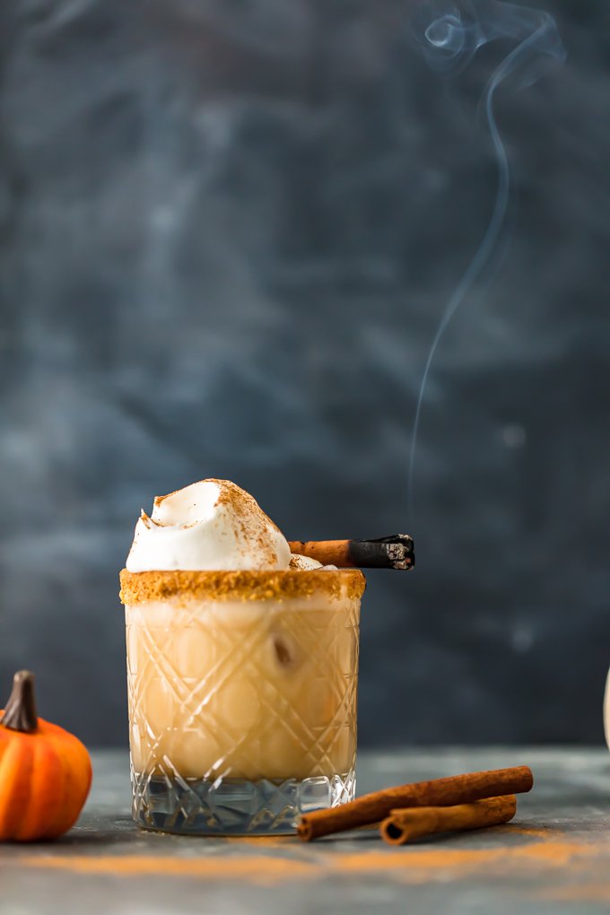 An old fashioned glass with a pumpkin spice white russian, topped with whipped cream