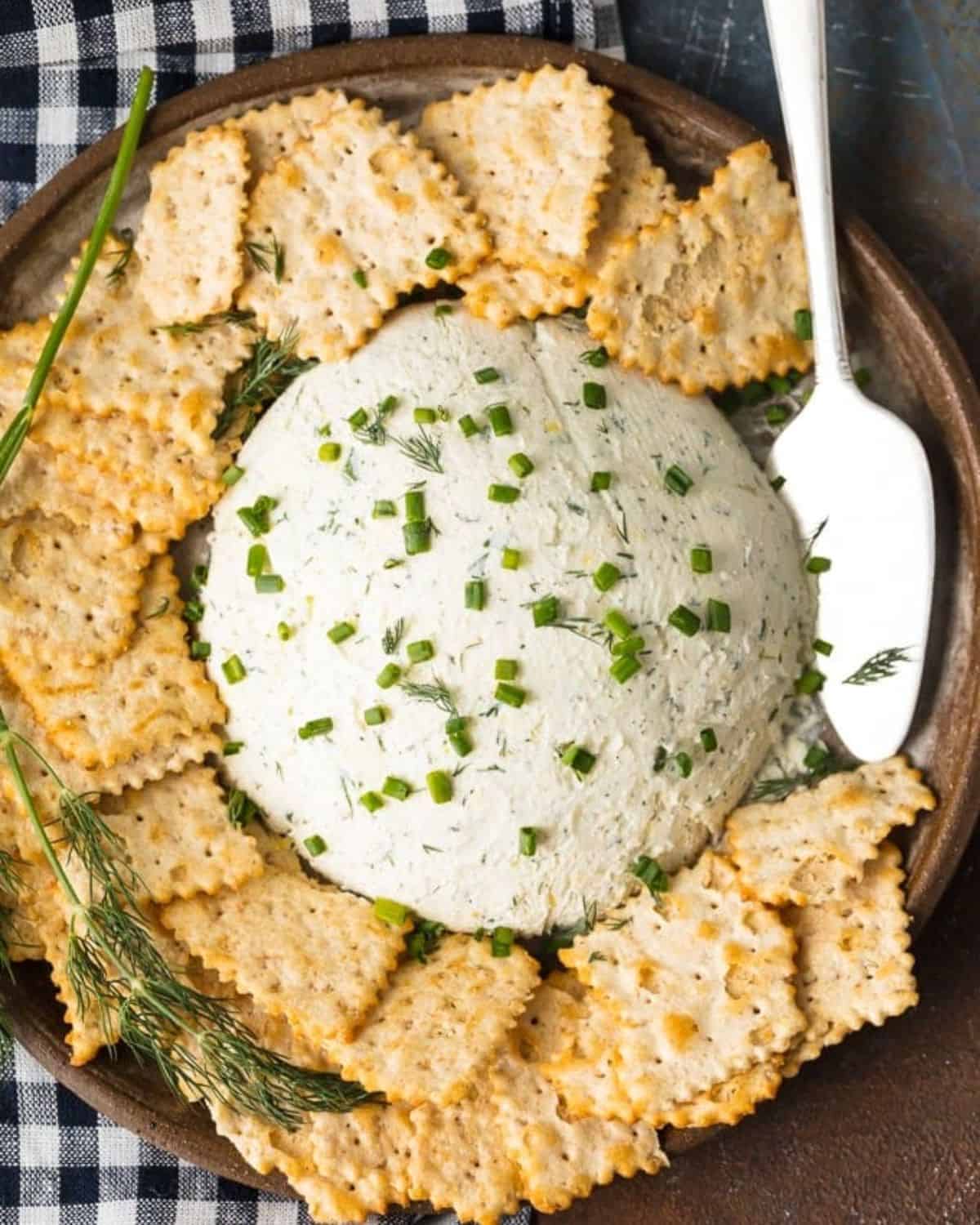 Herb Cream Cheese Dip is a simple yet delicious dip that's perfect for any party or any occasion. Serve it with crackers and guests will devour it! This Herb Coeur a la Creme recipe is savory, tasty, and super easy. There are so many uses for outside of dipping, you will be amazed! serving platter of herb cream cheese