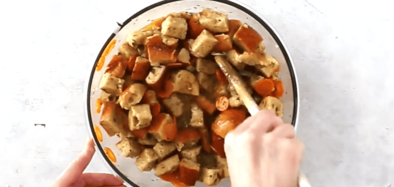 mixing bread cubes, veggies, broth, breadcrumbs, butter and spices in a bowl