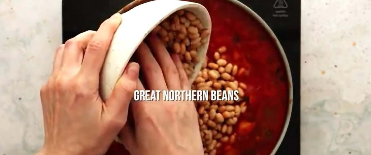 Adding beans to the soup pot. 