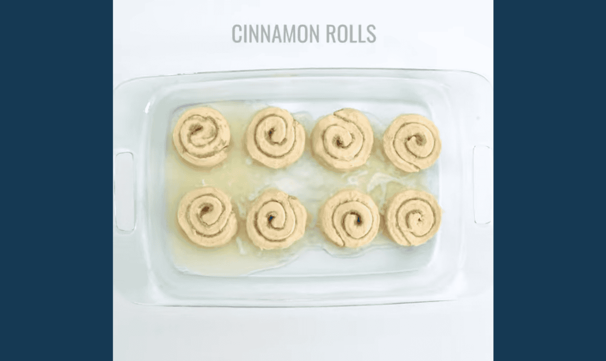 8 cinnamon rolls in a buttered baking pan.