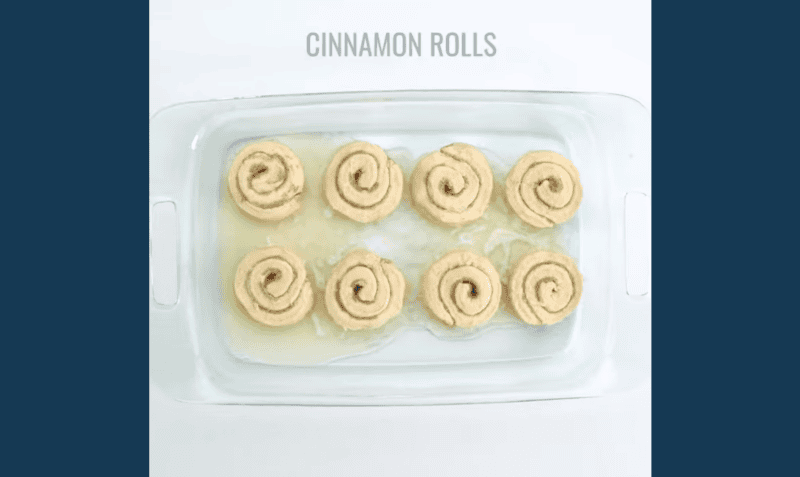 8 cinnamon rolls in a buttered baking pan.