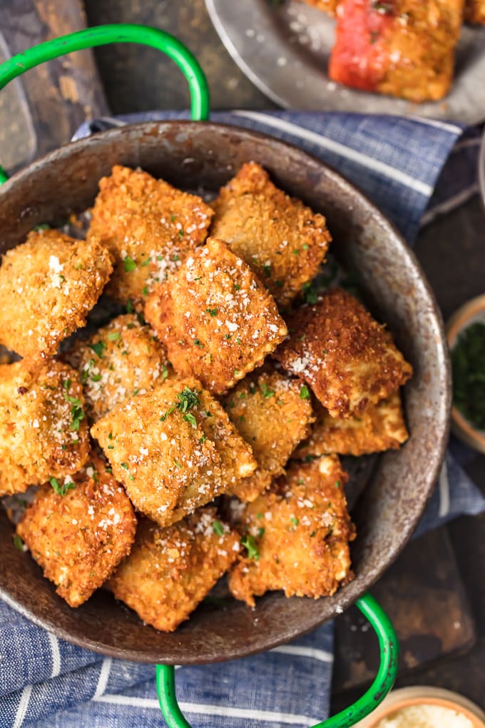 crispy ravioli in a green enameled pan.